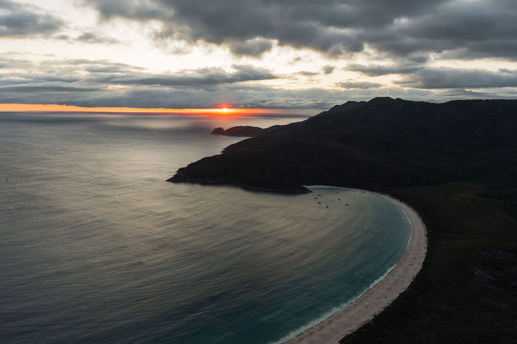 a sunset over a body of Freycinet